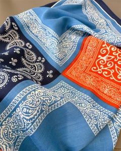 Close-up of blue and orange paisley silk scarf with detailed herringbone weave texture