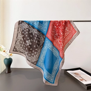 Detail view of large paisley square scarf with vibrant blue and red color-blocking design