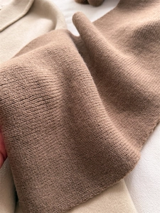 Détail de la maille côtelée marron caramel avec une texture douce en laine