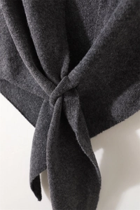 Detalle de bufanda de punto gris oscuro con textura suave y un diseño de nudo elegante