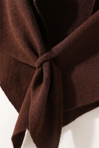 Detalle del tejido de punto marrón oscuro y el diseño de nudo del calentador de cuello