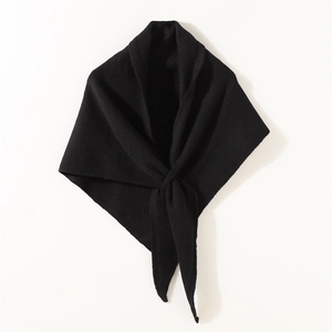 Primer plano de la textura del tejido negro y el detalle del nudo triangular drapeado