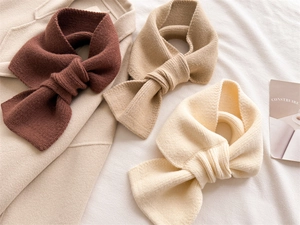 Detailed knit texture of solid-color winter scarves in coffee, camel, and cream beige shades