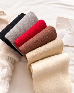 Macro shot of assorted warm knitted scarves in black, grey, red, and beige colors