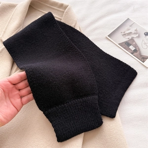 Close-up of black knitted neck warmer scarf with premium ribbed texture and soft fabric