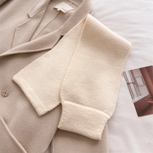 Close-up of ribbed knit edge and thick wool-like texture on a beige winter neck scarf