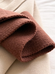 Detailed macro shot of warm caramel knitted fabric texture with soft wool-like finish
