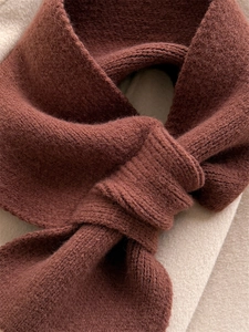 Detailed close-up of thick caramel brown knitted scarf showing soft texture and ribbed pattern