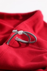 Detail of red fleece neck warmer featuring adjustable grey drawstring and plastic toggle