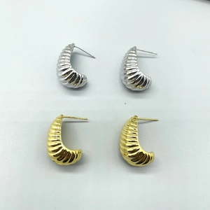 Dettaglio degli orecchini a goccia croissant con design a filettatura oro e argento