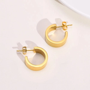Detail view of 18K gold plated minimalist C-shaped earrings with polished mirror finish