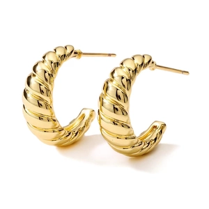 Macro detail of 18K gold plated C-shape earrings with a twisted croissant texture
