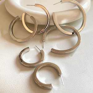 Detailed view of polished silver hollow C-hoop earrings in three different sizes