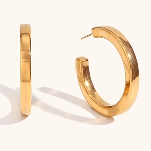Detail view of chunky golden hollow square hoop earrings with a high-polished finish