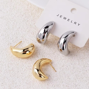 Detailed view of hollow teardrop earrings in polished gold and silver plated copper