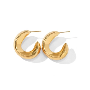 Macro view of chunky golden C-shaped hoop earrings with a polished mirror finish