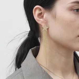Boucles d'oreilles pendantes étoile en or 18 carats portées par un mannequin chic