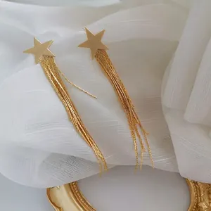 Boucles d'oreilles étoile dorée 18 carats avec pompons sur tulle blanc et cadre ancien