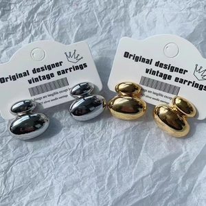 18K gold and silver plated metal pebble stud earrings set on a white display card
