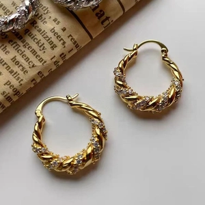 Detail of 18K gold twist hoop earrings with sparkling pavé cubic zirconia inlay