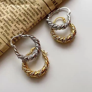 Detailed view of gold and silver twisted rope hoop earrings with pavé zircon setting
