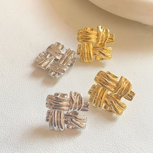 Close-up of woven metallic stripe square earrings in gold and silver finishes