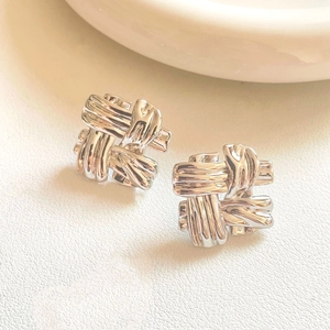Polished silver woven knot stud earrings with geometric textured metal stripes
