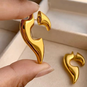 Polished gold plated abstract curved flame earrings for women with a modern artistic design