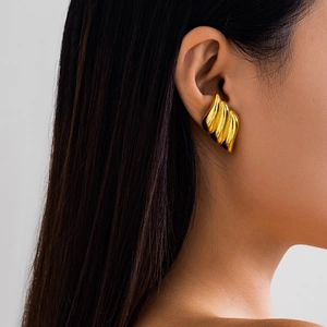 Close-up of 18K gold plated triple layered wing earrings on model with metallic finish