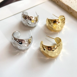 Hammered C-shape wide hoop earrings in gold and silver finish with textured metal design