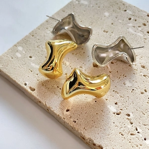 Irregular liquid metal style earrings in gold and silver finish with lava texture