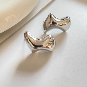 Detail view of silver-tone irregular geometric chunky earrings with a high-polish finish