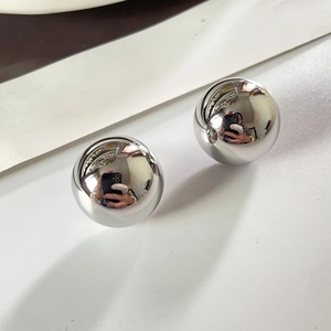 Gros plan de boucles d'oreilles boules minimalistes avec finition miroir poli