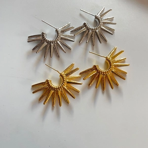 Modern gold and silver sunflower C-shape hoop earrings with textured metal surface