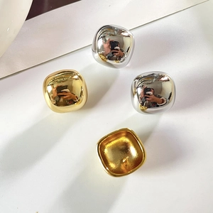 Vue détaillée de boucles d'oreilles carrées brillantes en finitions dorées et argentées