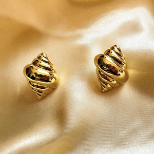 Polished 18K gold plated conch shell earrings on a luxury golden satin background