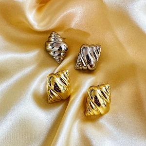 Chic 18K gold and silver plated conch shell earrings displayed on elegant silk fabric