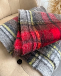 Detail of red and yellow plaid mohair scarf showing soft brushed texture and thick fringe
