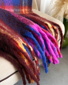 Close-up of vibrant rainbow checkered scarf featuring thick tassels and mohair texture