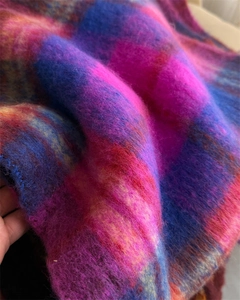 Close-up of soft rainbow plaid mohair fabric with vibrant purple and orange fuzzy texture