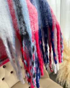 Macro view of colorful rainbow mohair plaid scarf showing soft fuzzy texture and tassels
