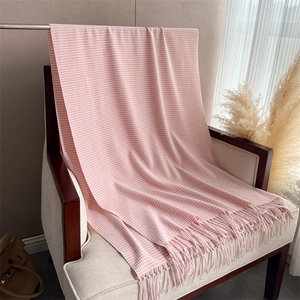 Dettagli della sciarpa rosa e bianca con motivo pied-de-poule e lunghe frange