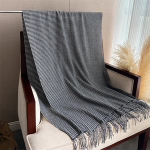 Dettaglio della sciarpa in cashmere pied-de-poule bianco e nero con le frange