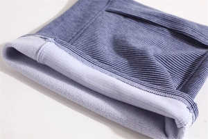 Macro detail of striped knit neck warmer with soft fleece lining and reinforced stitching