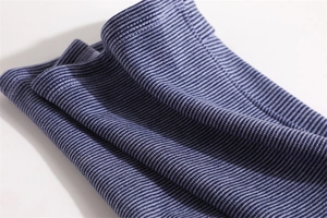 Close-up of blue and white striped knit neck warmer fabric showing fine stitching detail