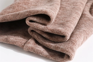 Close-up of the thick brown knitted fabric with soft fleece lining for winter warmth