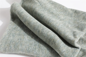 Detail of plush thermal neck warmer fabric in light green and grey-blue textured knit