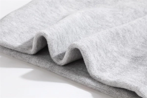 Macro view of light grey thermal fleece fabric showing soft texture and thick plush fibers