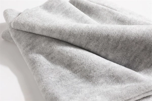 Close-up of thick light gray plush fabric showing soft fleece texture and warm fibers