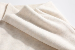 Close-up of soft cream thermal fleece fabric texture with natural fluffy folds